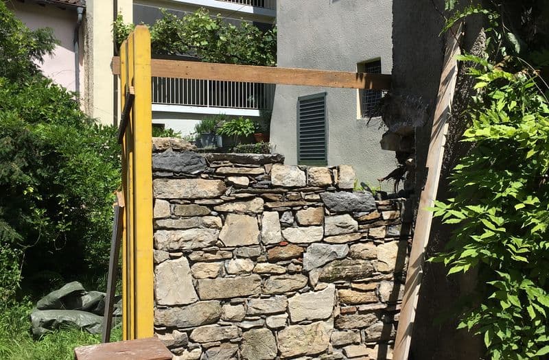 Muro a secco in sassi in costruzione sotto la tettoia di una casa