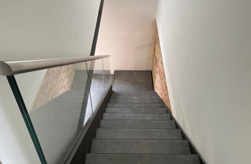 Scala interna in acciaio nero con parapetto in vetro, vista dall'alto